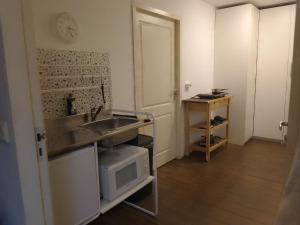 a small kitchen with a sink and a microwave at B&B Bij Greet in Sellingen
