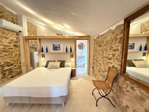 a bedroom with two beds and a chair in it at Agi Porthos Apartments in Roses