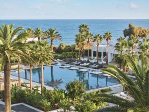an aerial view of a resort with palm trees and a pool at Grecotel LUXME White in Adelianos Kampos