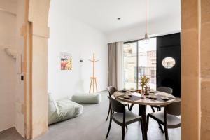 a dining room with a table and chairs at Opificio Angiolino Luxury Residence in Melendugno