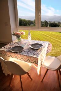 einen Tisch mit zwei Stühlen und eine Vase mit Blumen darauf in der Unterkunft La Colombière - Vue imprenable sur l'Ardèche - Très Calme - Très bien situé - Résidence Privée in Montélimar
