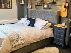 a bedroom with a bed with a guitar and a nightstand at Christmas Cottage in Doveridge