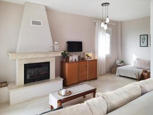 a living room with a couch and a fireplace at Silver Moon Villa in Achlia