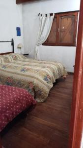 a bedroom with two beds and a wooden floor at Casa tafi del valle in Tafí del Valle