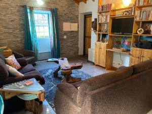 a living room with two couches and a tv at Adega Baia do Canto AL 1398 in Terra Alta