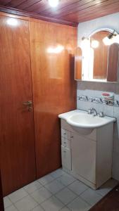 a bathroom with a sink and a wooden door at Casa tafi del valle in Tafí del Valle