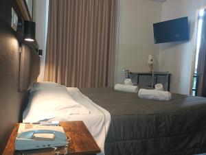 a hotel room with a bed with a phone on a table at Hotel MM Dateo in Milan