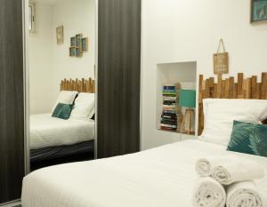 a bedroom with two beds and a mirror at Les Sablettes in Menton