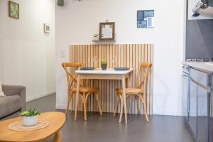 a small kitchen with a small table and chairs at Les Sablettes in Menton