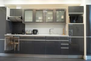 a kitchen with gray cabinets and a sink at Les Sablettes in Menton