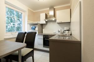 ビンツにあるHaus am Großbahnhof Whg 1のシンクとテーブルと椅子のあるキッチン