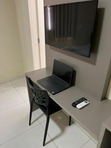 a laptop computer sitting on a desk with a chair at Grace Palace Hotel in Sobral