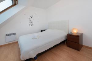 a bedroom with a bed and a nightstand with a lamp at Maison Familiale moderne 5p in Sainte Anne d'Auray 