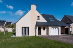a white house with a black roof at Maison Familiale moderne 5p in Sainte Anne d'Auray 