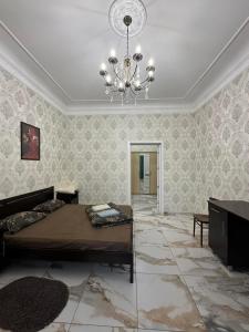 a bedroom with a bed and a chandelier at Апартаменти в парку in Umanʼ
