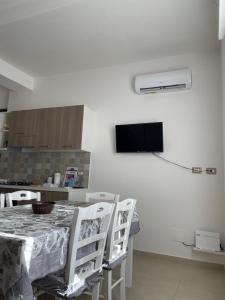 a kitchen with a table with chairs and a television at CASA VACANZE CASANOVA in Agerola