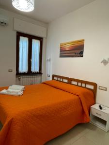 an orange bed in a white room with a window at CASA VACANZE CASANOVA in Agerola