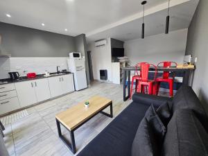 a living room with a couch and a table and a kitchen at Loft Los Sauces 850 in General Roca
