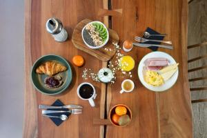a wooden table topped with plates of breakfast foods at Appart'City Confort Pau Centre in Pau