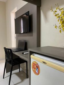 a kitchen with a table and a laptop on a desk at Grace Palace Hotel in Sobral