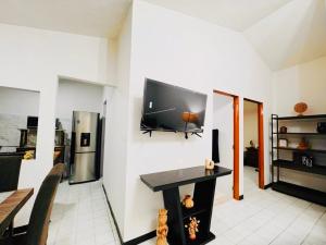 a living room with a flat screen tv on a wall at Casa Orquídeas Oaxaca in Oaxaca City