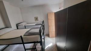 地拉那Crew Hostel 2的一间卧室配有两张双层床和一个衣柜