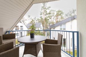 a patio with a table and chairs on a balcony at Haus am Großbahnhof Whg. 3 in Binz