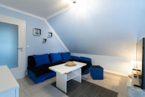 a living room with a blue couch and a white table at Haus am Großbahnhof Whg. 3 in Binz