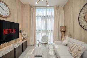 a living room with a white couch and a tv at 1Bedroom Apartment Oak Luxury by Blue Cloud Holidays in Sharjah