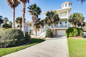 a large white house with palm trees and a sidewalk at Tybee Island Gem: Spacious Home w/ Private Pool in Tybee Island