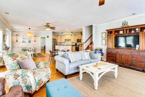 a living room with a couch and a tv at Tybee Island Gem: Spacious Home w/ Private Pool in Tybee Island