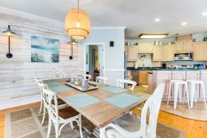 a kitchen and dining room with a wooden table and chairs at Tybee Island Gem: Spacious Home w/ Private Pool in Tybee Island