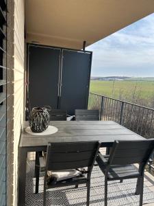 a table and chairs on a balcony with a view at Apartmán s parkovacím miestom in Nitra