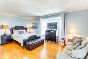 a bedroom with a bed and a tv and a couch at Tybee Island Gem: Spacious Home w/ Private Pool in Tybee Island +32 photos