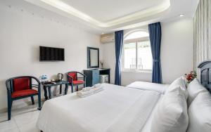 a hotel room with two beds and a tv at La Casona Boutique Hotel in Ho Chi Minh City