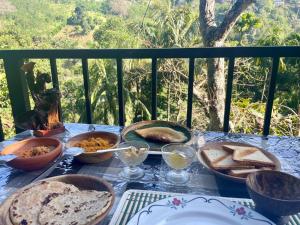 a table topped with plates and bowls of food at Green Glow Cottage Ella in Ella