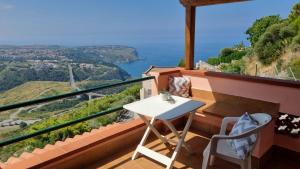 ein Balkon mit Tisch und Stühlen und dem Meer in der Unterkunft Casa Emma in San Nicola Arcella