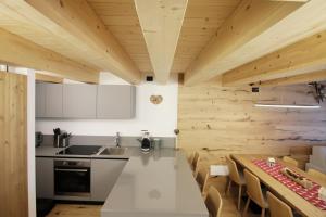 a kitchen with wooden walls and a table and chairs at ALPINE LOFT - Residence Veronza con piscina, Dolomiti Affitti in Cavalese +54 photos