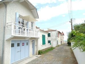 Casa blanca con puerta azul y balcón en Hélios Saint Gilles Croix de Vie, en Les Bussolleries