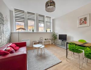 a living room with a red couch and a table at Lumineux & Cosy, Hyper Centre Metz in Metz