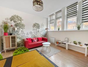 a living room with a red couch and some windows at Lumineux & Cosy, Hyper Centre Metz in Metz