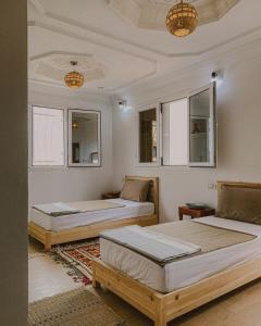 two beds in a room with windows at Dania Surf House in Mirleft +30 photos