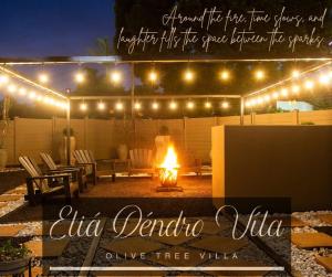 a person standing under a tent with a fire under lights at Eliá Dendró Víla in Lydenburg