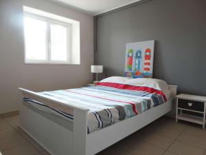 a white bed in a room with a window at Quatre Vents Saint Hilaire de Riez in Saint-Hilaire-de-Riez