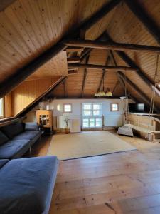 Cette grande chambre mansardée dispose d'un canapé et d'un grand tapis. dans l'établissement Ferienwohnung für 6 Personen in Moorhausen, à Varel