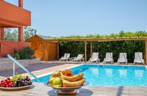 a bowl of fruit next to a swimming pool at Rooms Natura in Vilanija