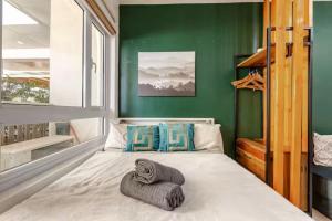 a bed in a room with a green wall at 4-Pax Studio w FREE Parking, 5 mins to Sky Ranch in Tagaytay