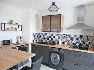 a kitchen with a sink and a washer and dryer at Gardénia Saint Gilles Croix de Vie in Le Sablais +3 photos