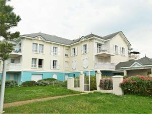 a large apartment building with a fence and flowers at Gardénia Saint Gilles Croix de Vie in Le Sablais