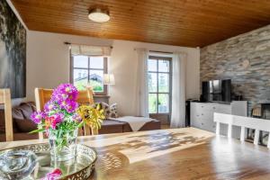 a living room with a table with flowers on it at Ferienhaus Waldhaus in Grafenau
